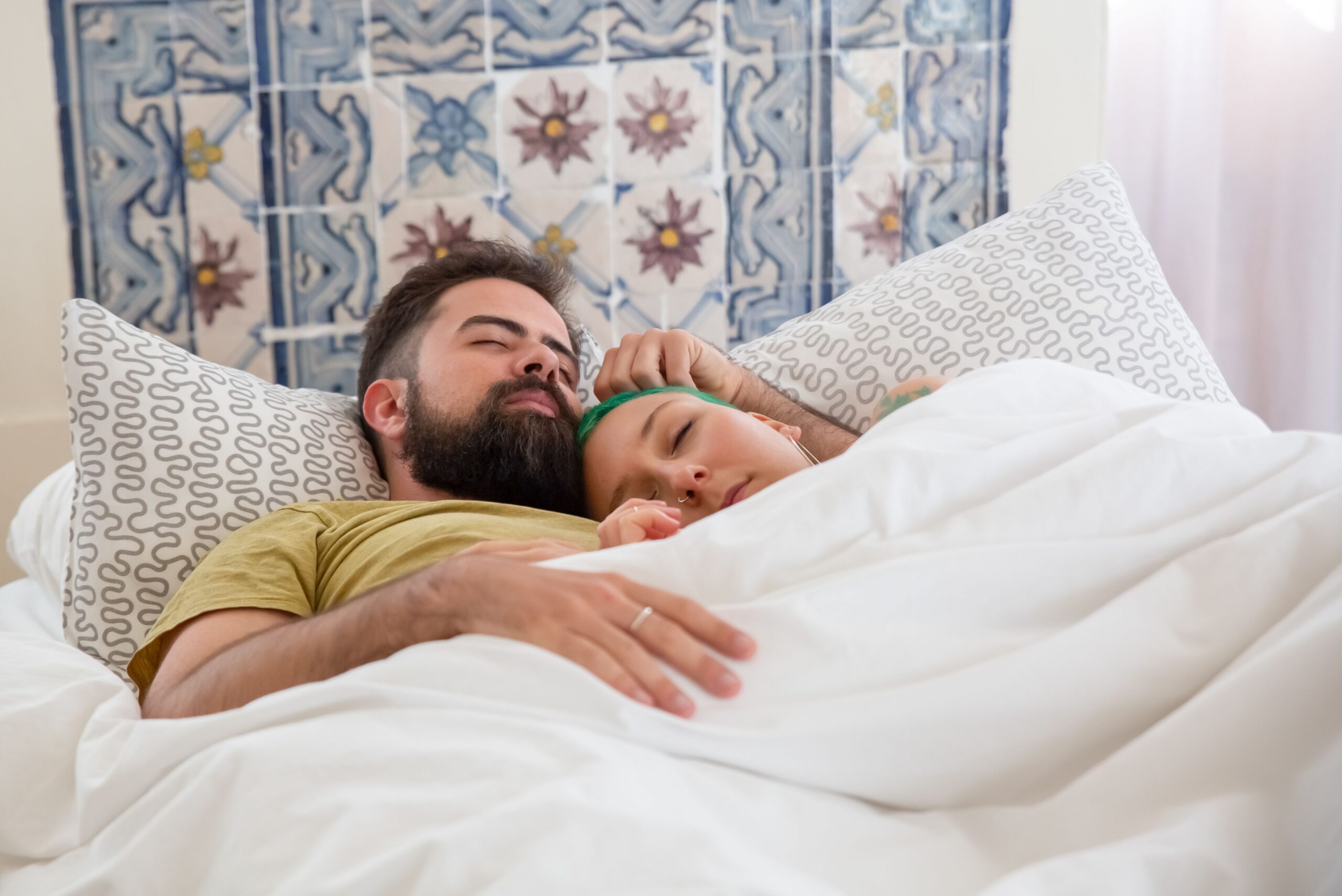 pareja en cama con almohadas cervicales mariposa confort
