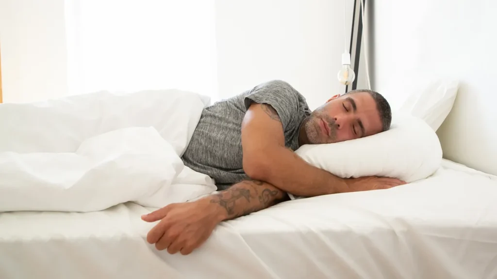 hombre durmiendo de lado sobre una almohada viscoelástica